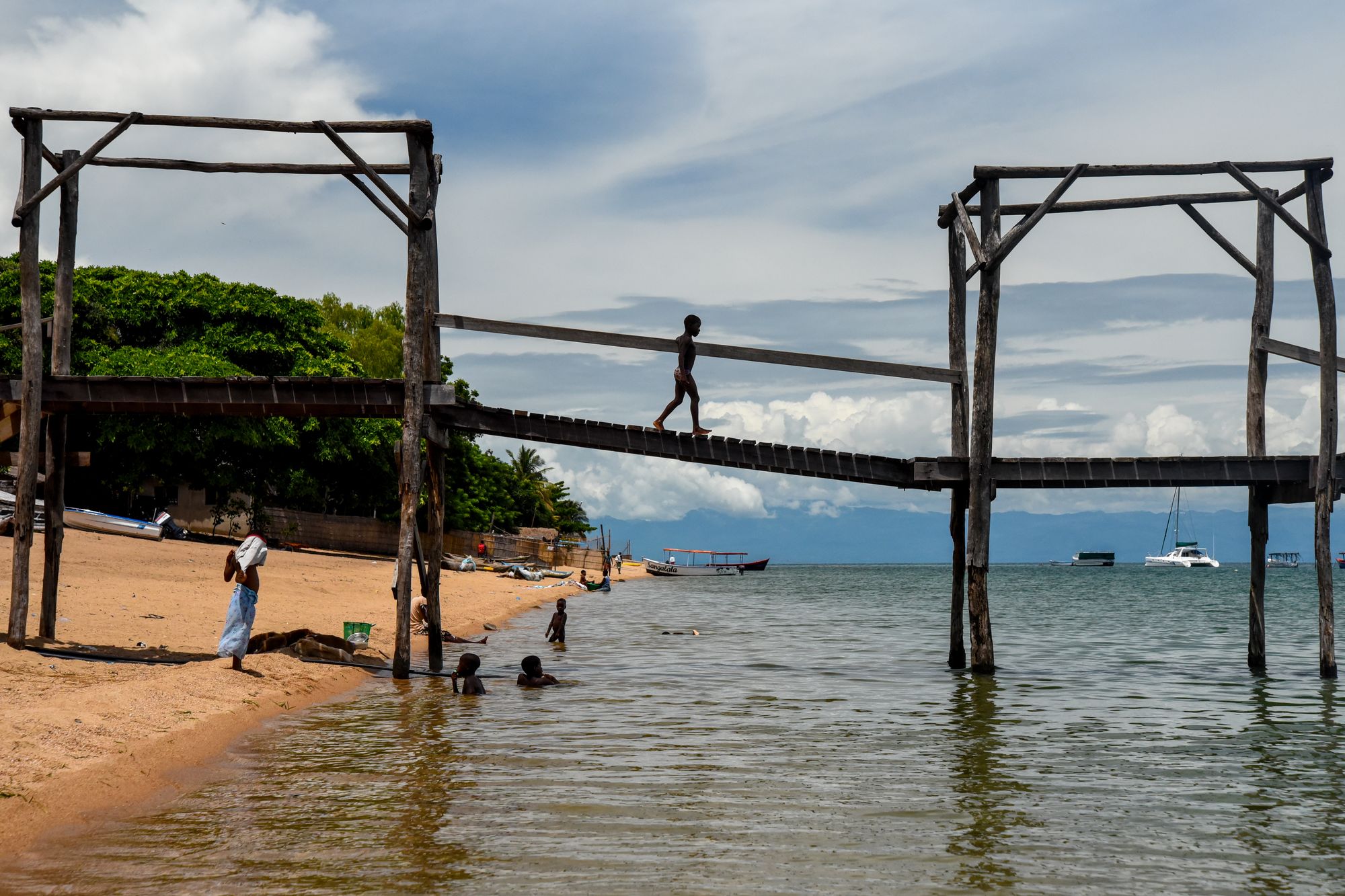 Children crossing a wooden jetty over the lake